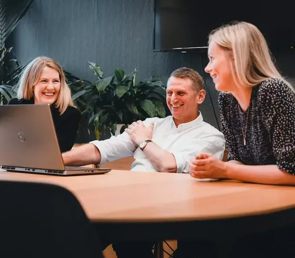 3 Zelst team members sat round a table with a laptop.