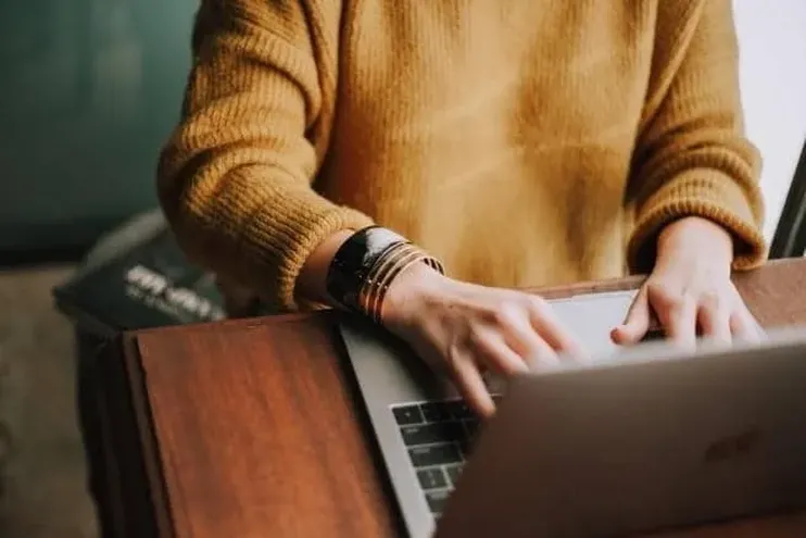 A person republishing content on a laptop.
