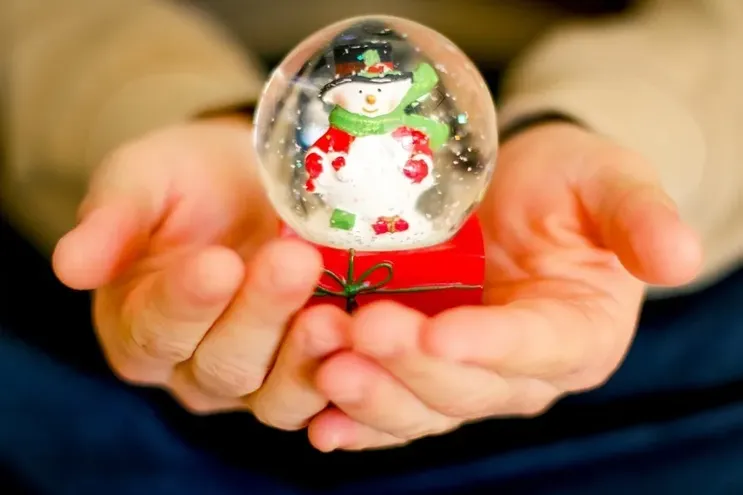 Snowglobe placed in a person's hands.